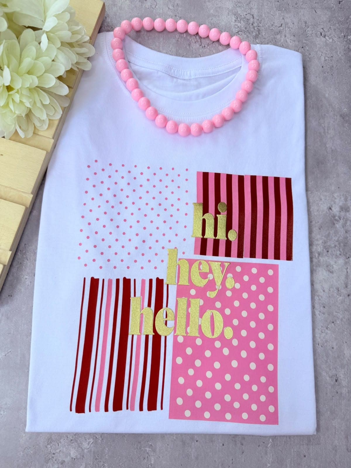 Camiseta blanca con cuadros de lunares y rayas y la frase hi hey hello