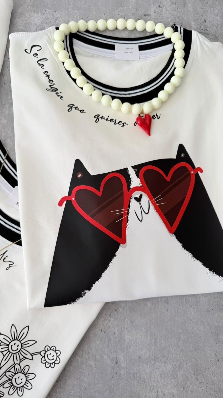 Camiseta blanca con dos gatos con gafas de corazón, cuello a rayas