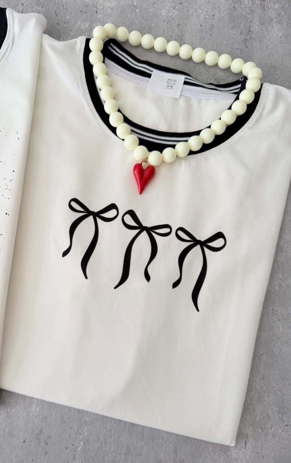 Camiseta blanca con tres lazos negros y cuello negro
