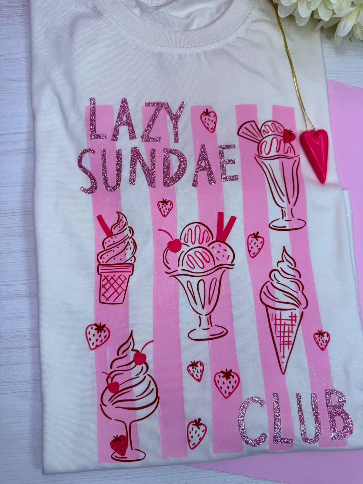 Camiseta blanca con rayas rosadas, helados y la frase Lazy Sundae Club