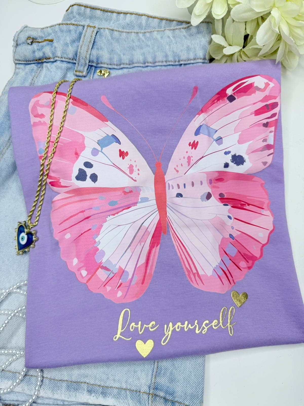 Camiseta lila con mariposa rosada y la frase Love yourself