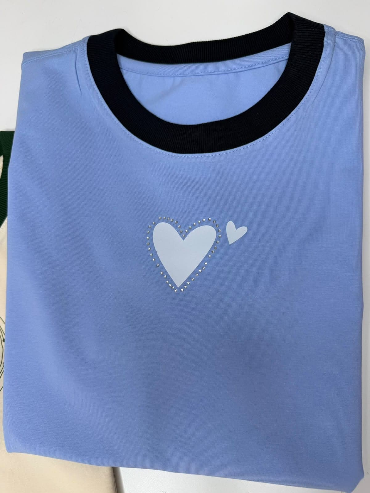 Camiseta azul claro con cuello negro y corazón blanco