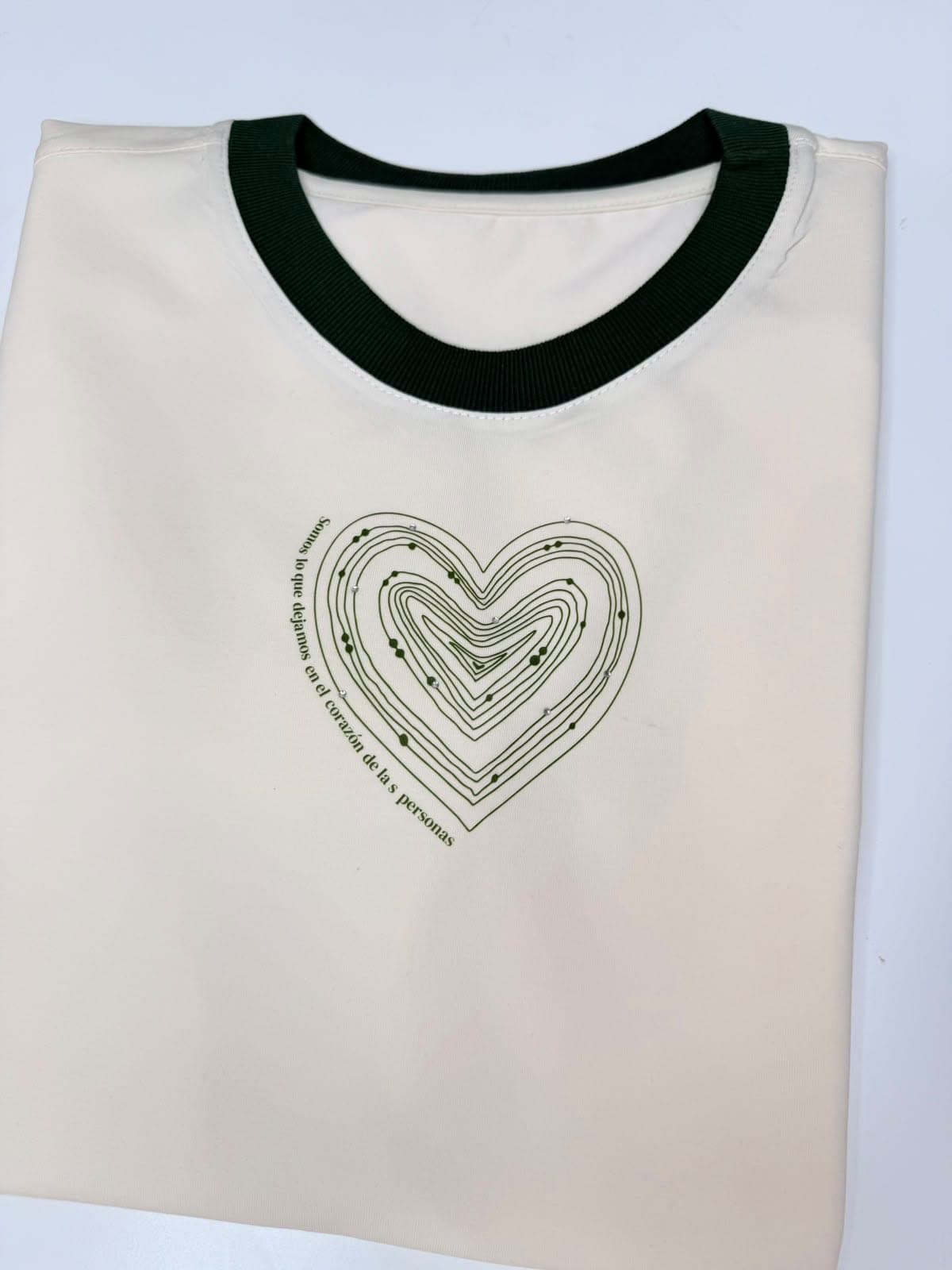 Camiseta crema con cuello verde y corazón de líneas