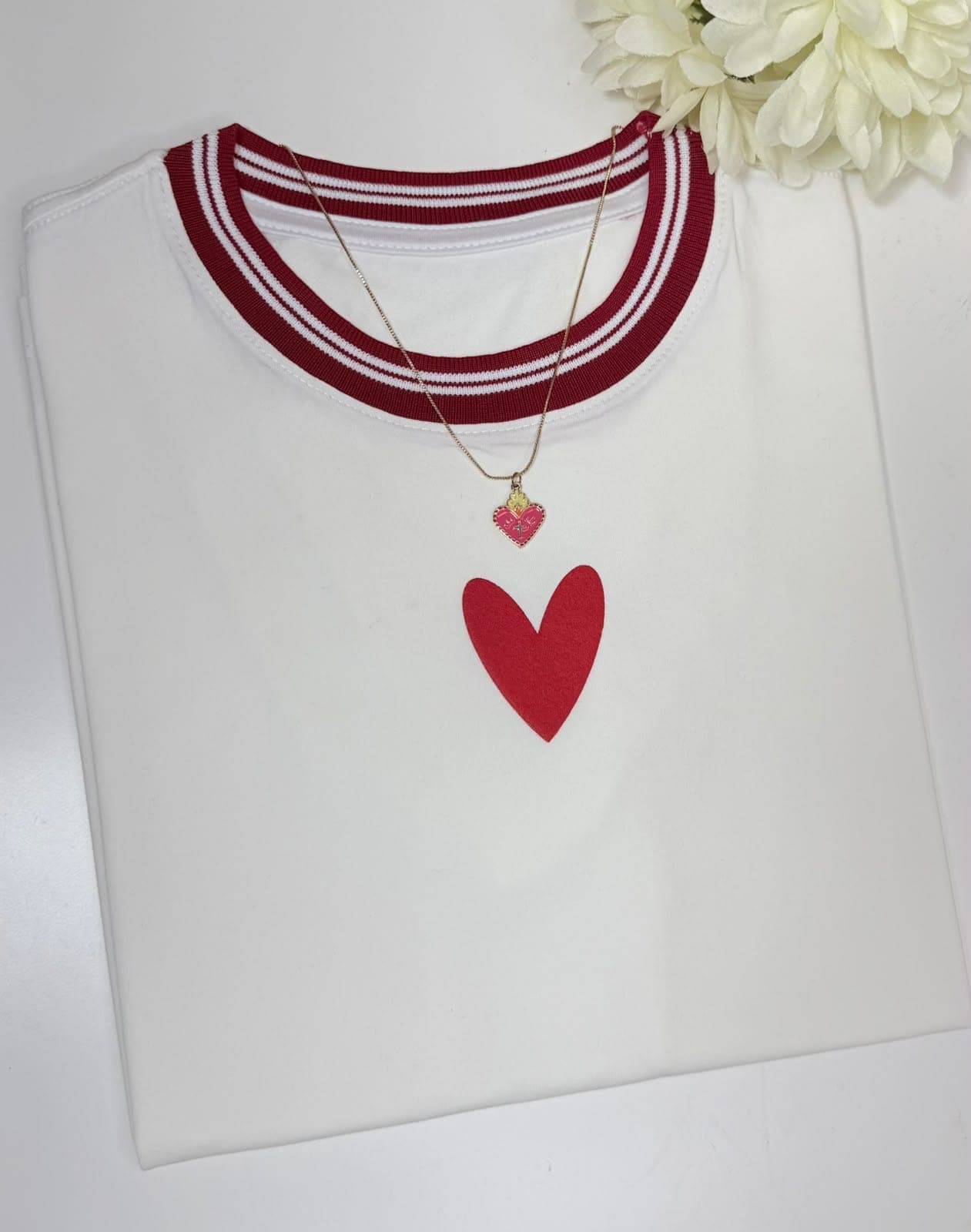 Camiseta blanca con cuello rojo a rayas y corazón rojo pequeño