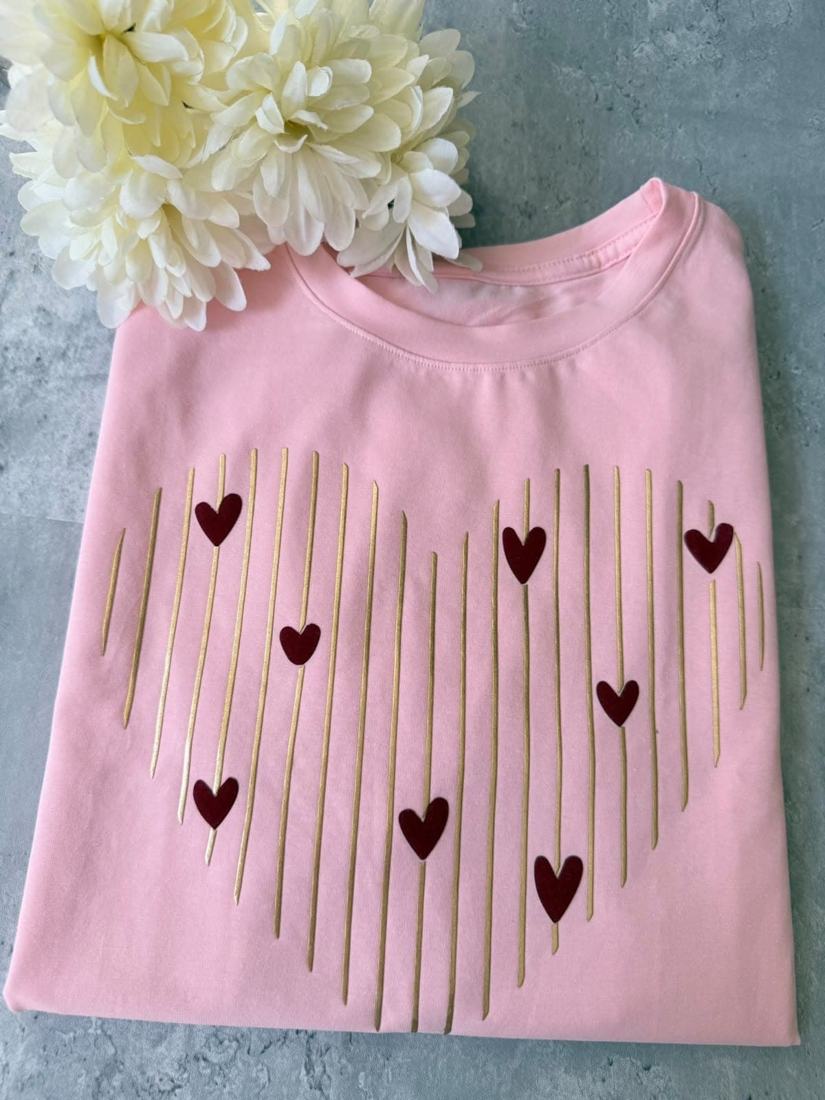 Camiseta rosada con corazón de líneas doradas y corazones vino