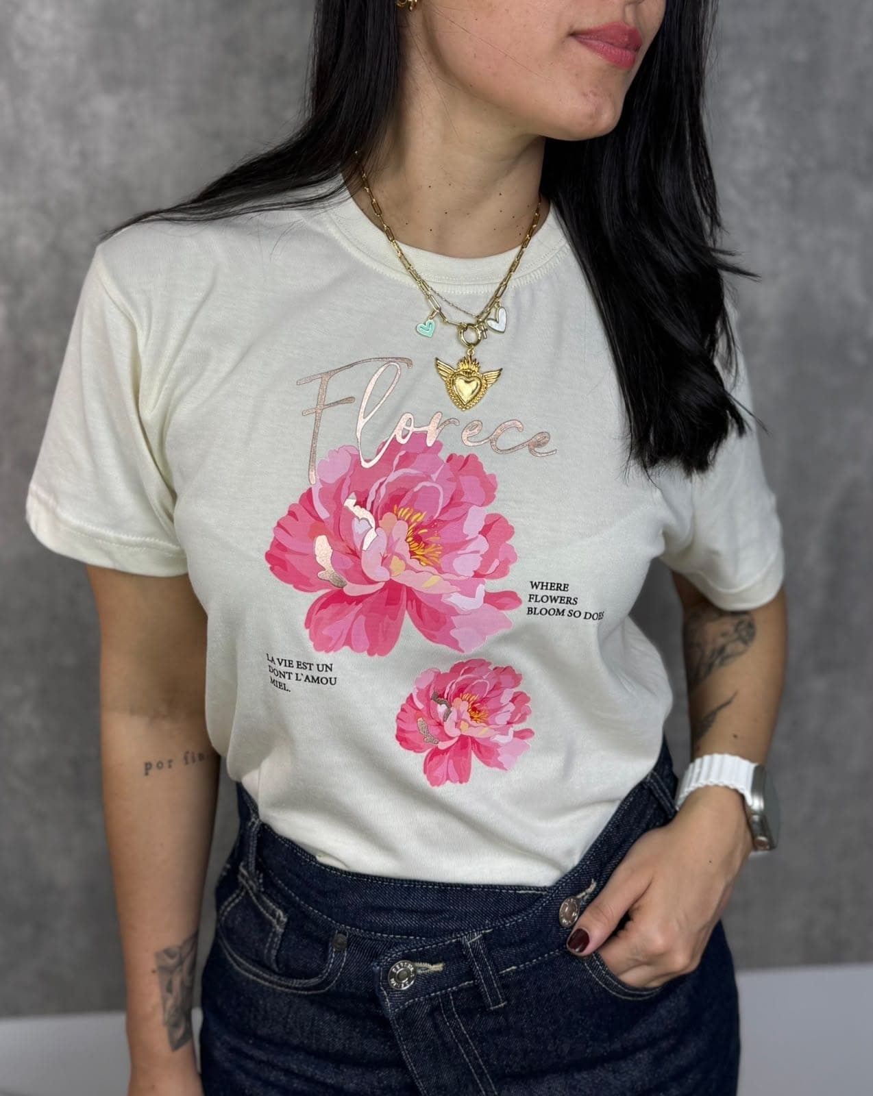 Modelo con camiseta crema con peonías rosadas y la palabra Florece