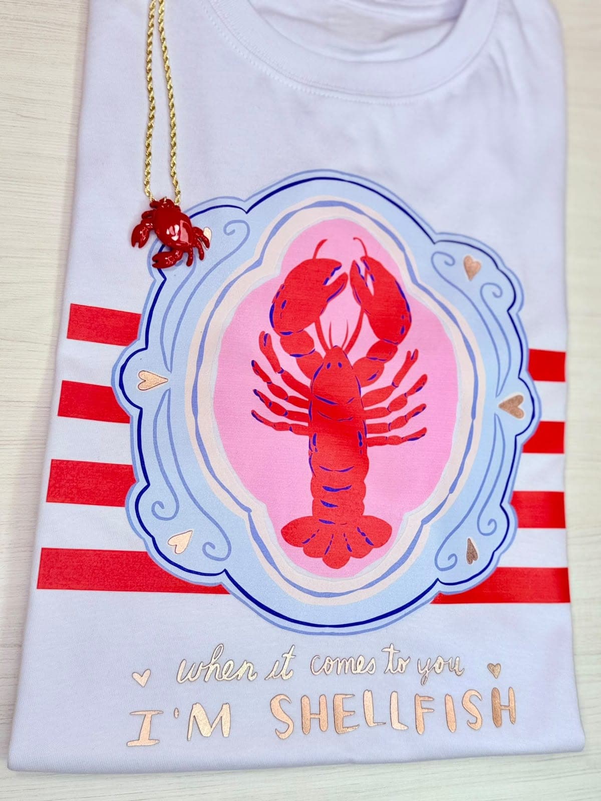 Camiseta blanca con langosta en marco y la frase I'm shellfish