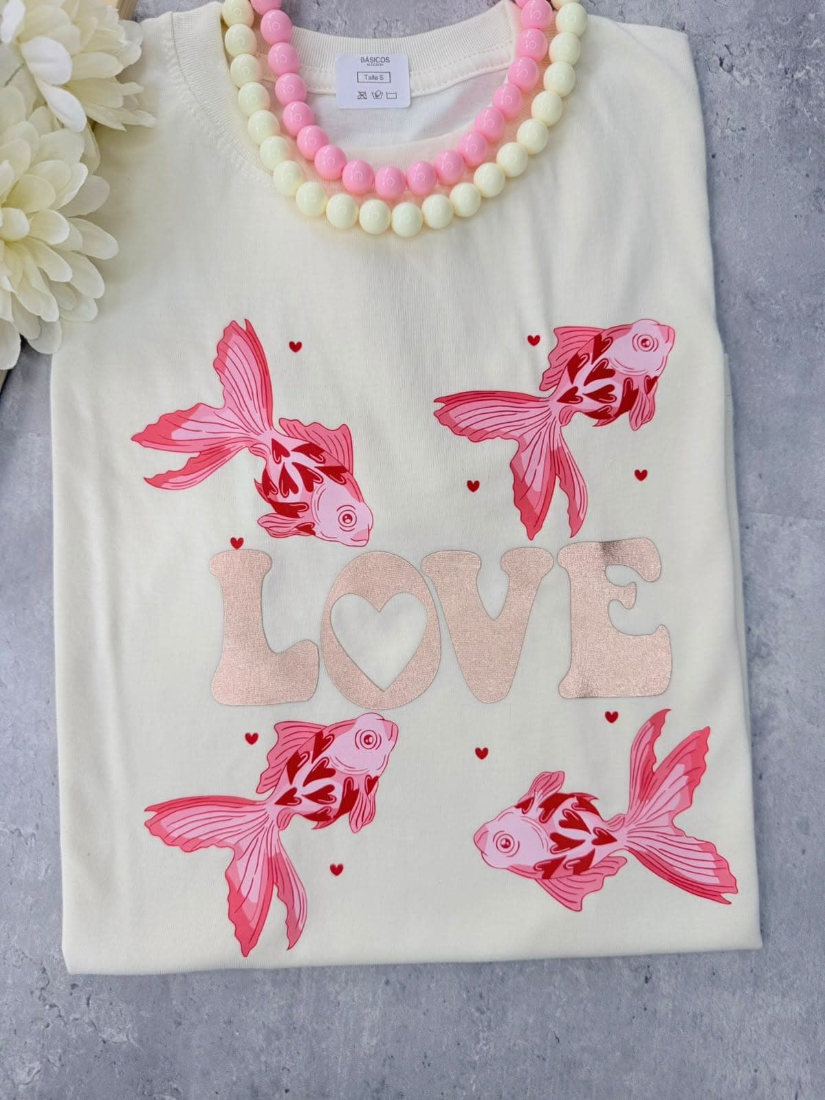 Camiseta crema con peces rosados y la palabra Love