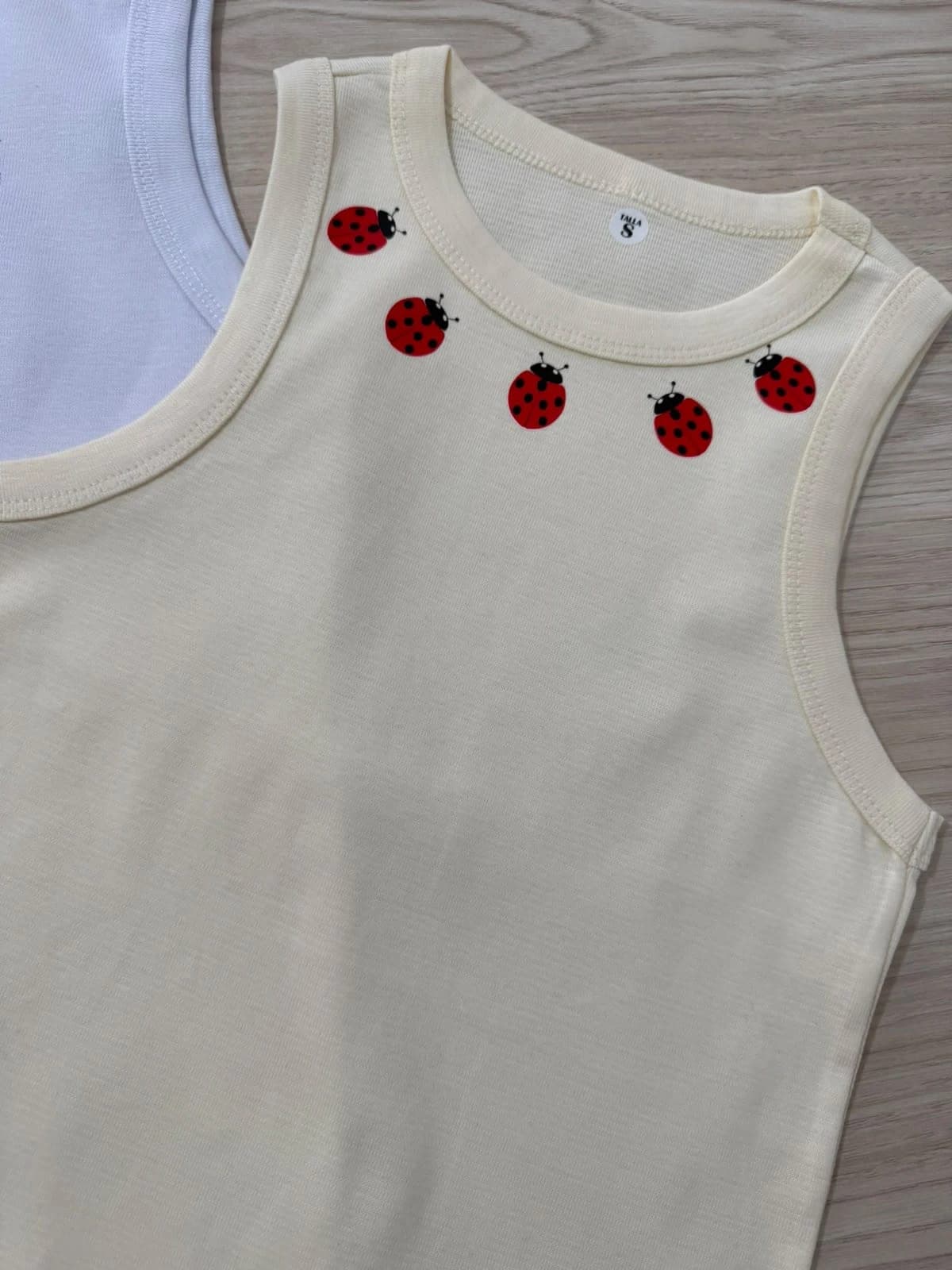 Tank top crudo con mariquitas alrededor del cuello