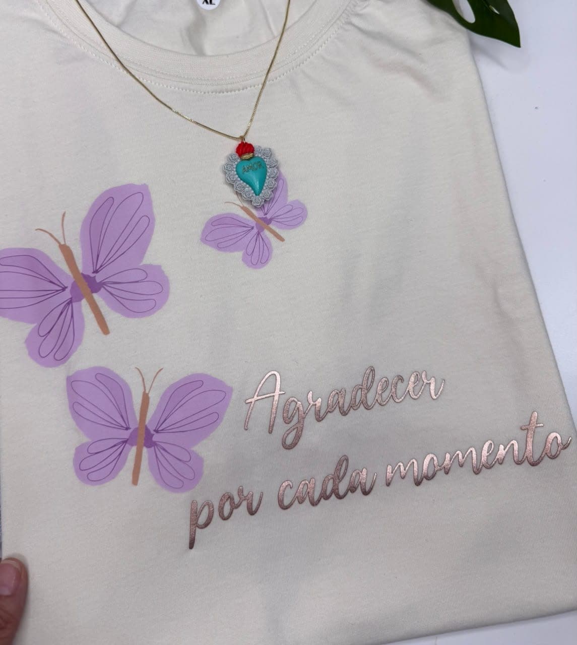 Camiseta blanca en tela fría con mariposas lila y la frase Agradecer por cada momento