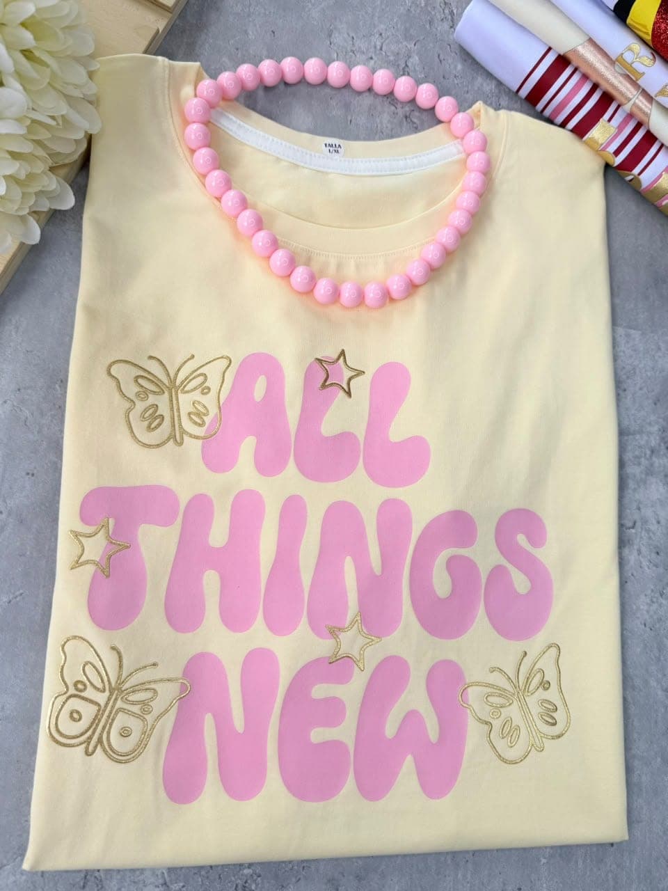 Camiseta mantequilla en tela fría con mariposas y la frase All things new