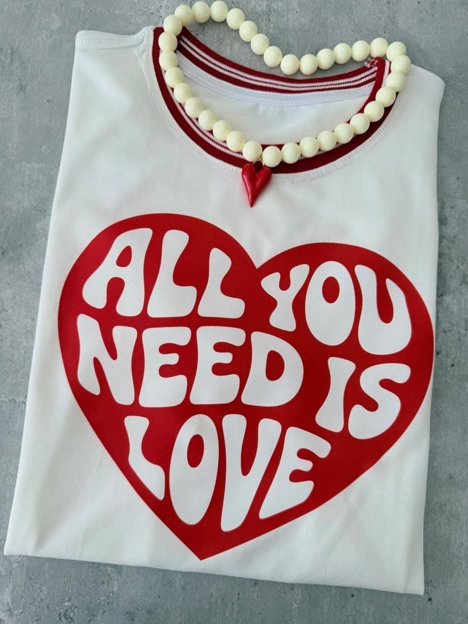 Camiseta crema en tela fría con cuello a rayas y corazón rojo All you need is love
