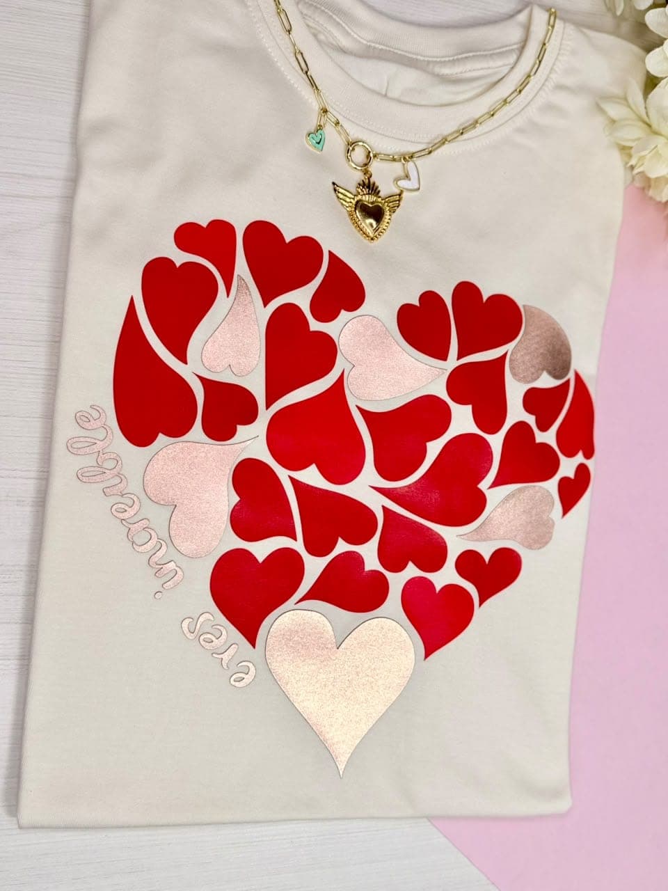 Camiseta crema en tela fría con corazón hecho de corazones y la frase eres increíble